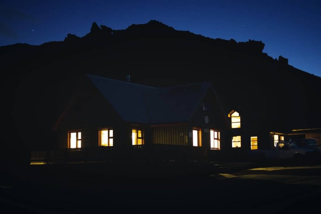 Lights glow from inside of a house at nighttime.