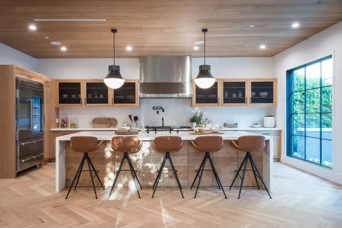 Lights glow inside of a modern kitchen with brown finishes.