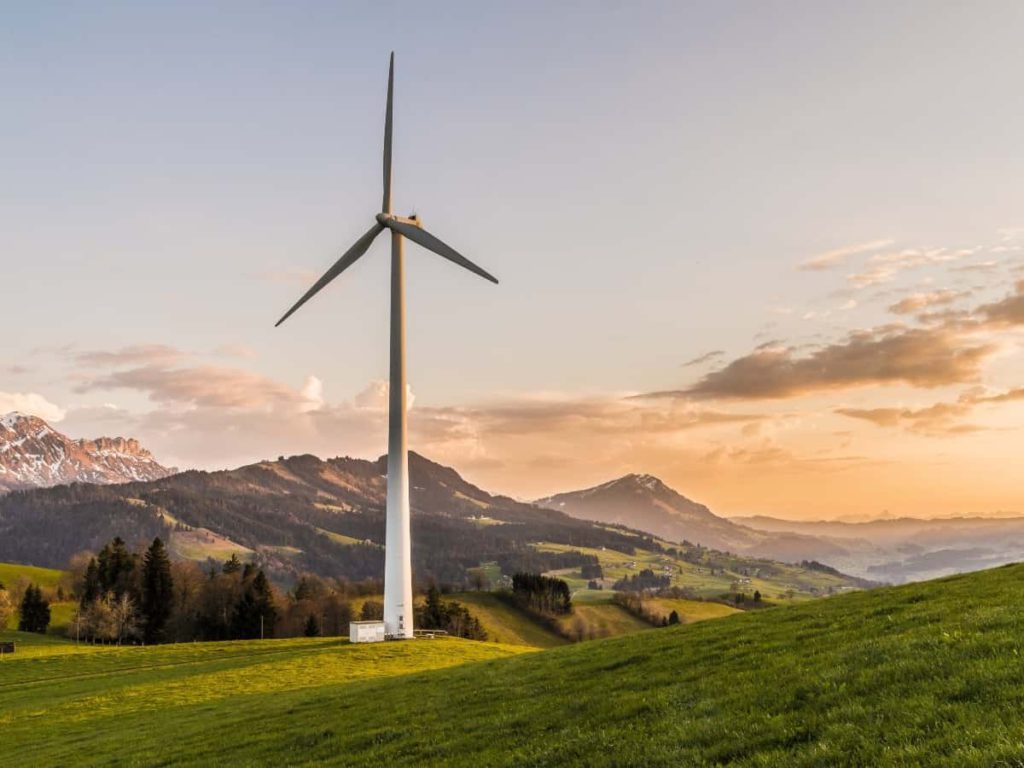 a wind turbine, a form of renewable energy in front of mountain on the coast