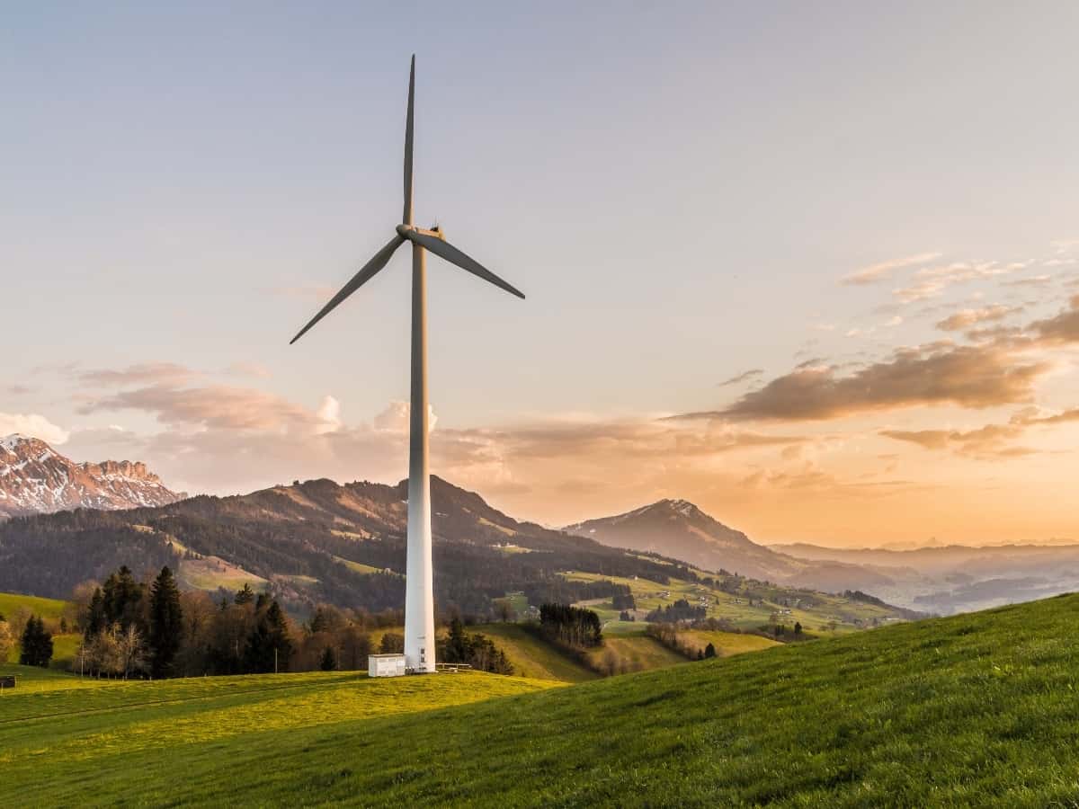 a wind turbine, a form of renewable energy in front of mountain on the coast