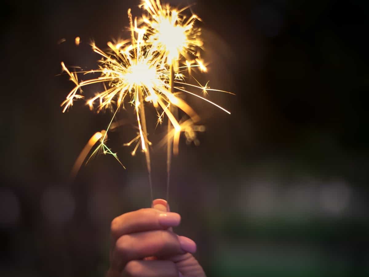 a hand holding a sparkler practicing safety