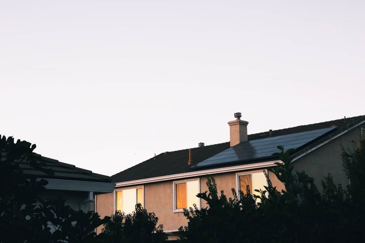 A stucco home with solar panels installed on roof.