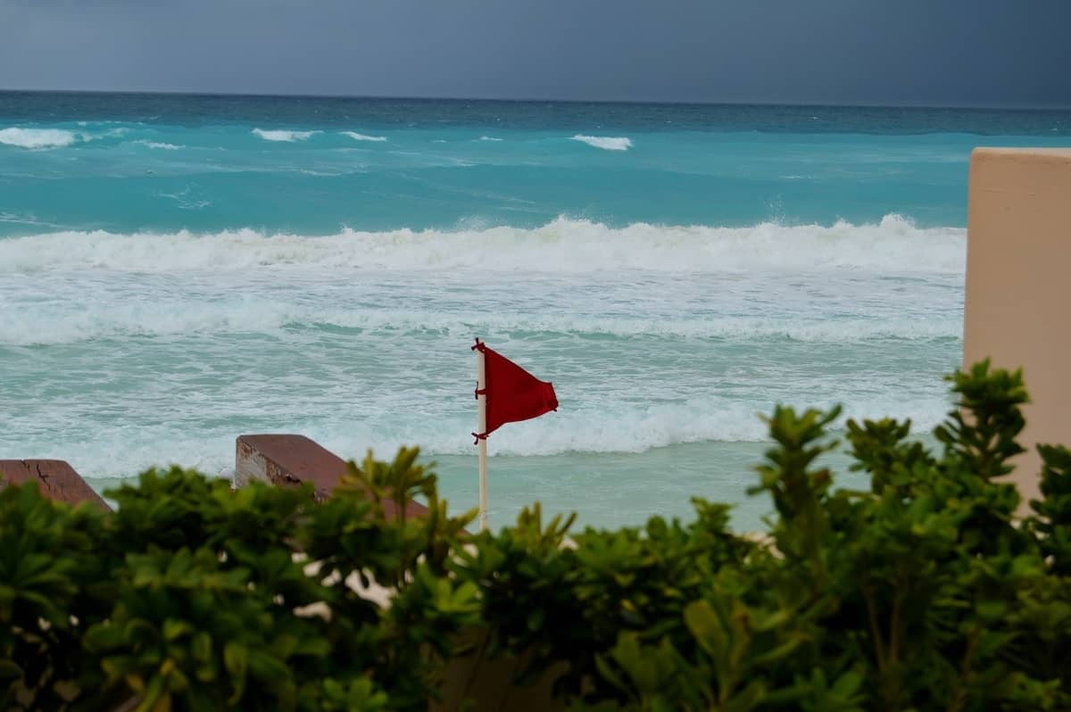 A red flag is waving on a beach to warn about an approaching hurricane.