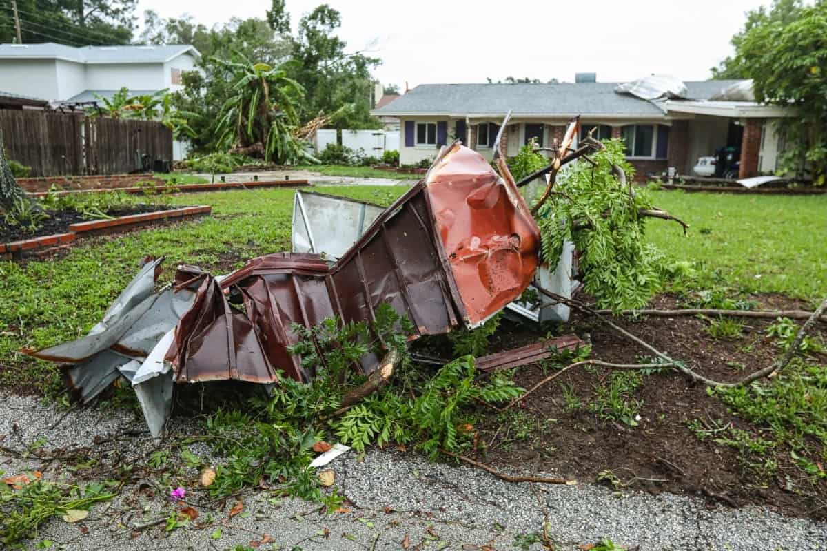 Storm debris lays outside on the front yard of a home.