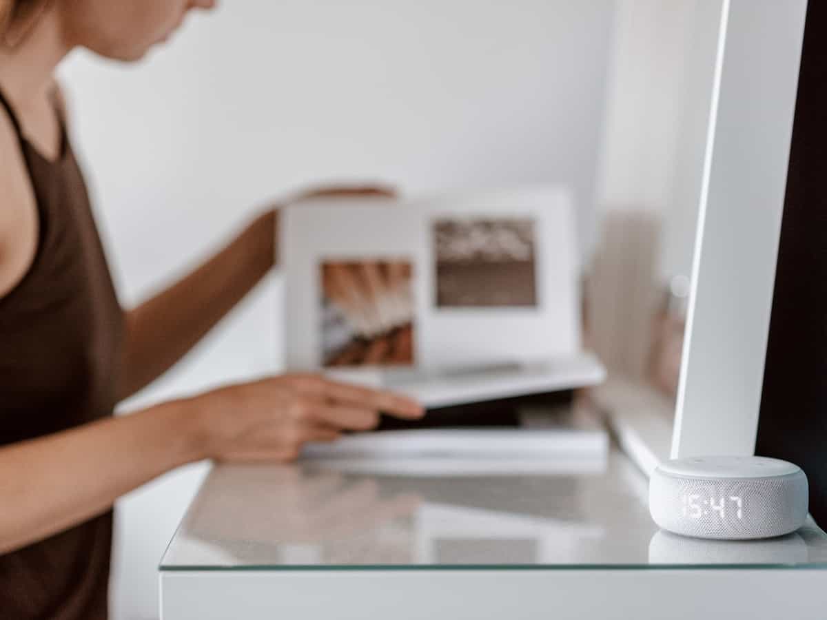 someone flipping through a magazine with an Alexa on the corner of her desk