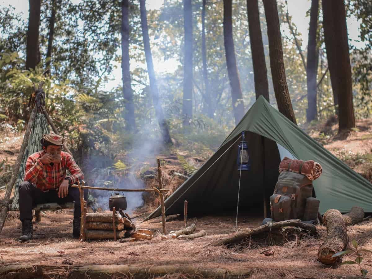 a tent set up with a fire during a camping trip