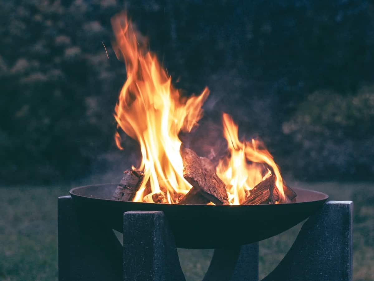 a flame coming out of a backyard fire pit