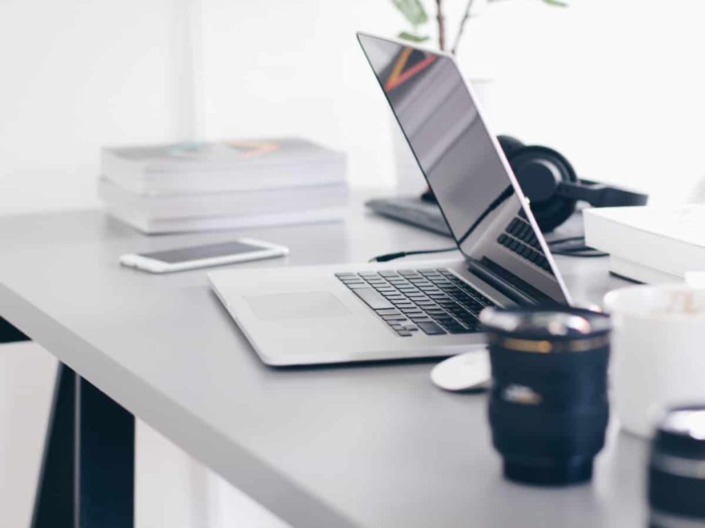 a half closed laptop on a desk with an empty screen