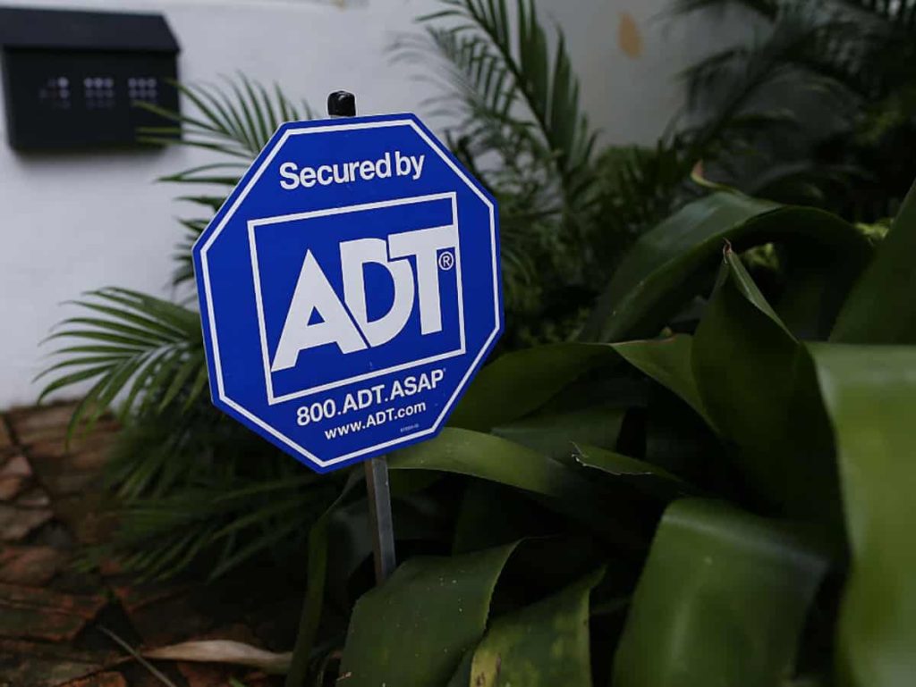 a security sign in the front yard of someone's home to keep burglars away