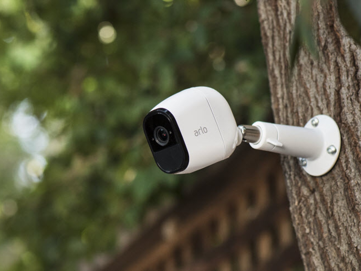 an arlo security camera mounted onto a tree
