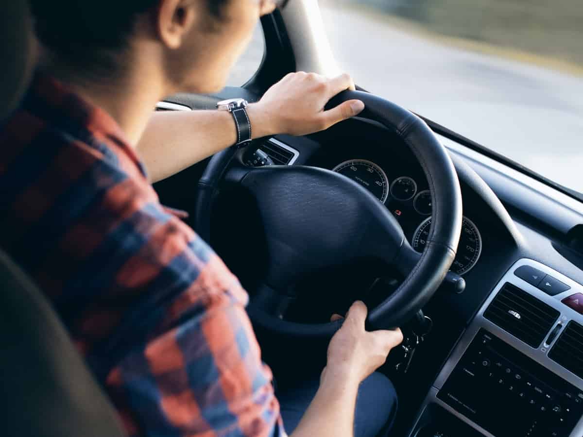 close up of someone driving on a road that has auto insurance for their car