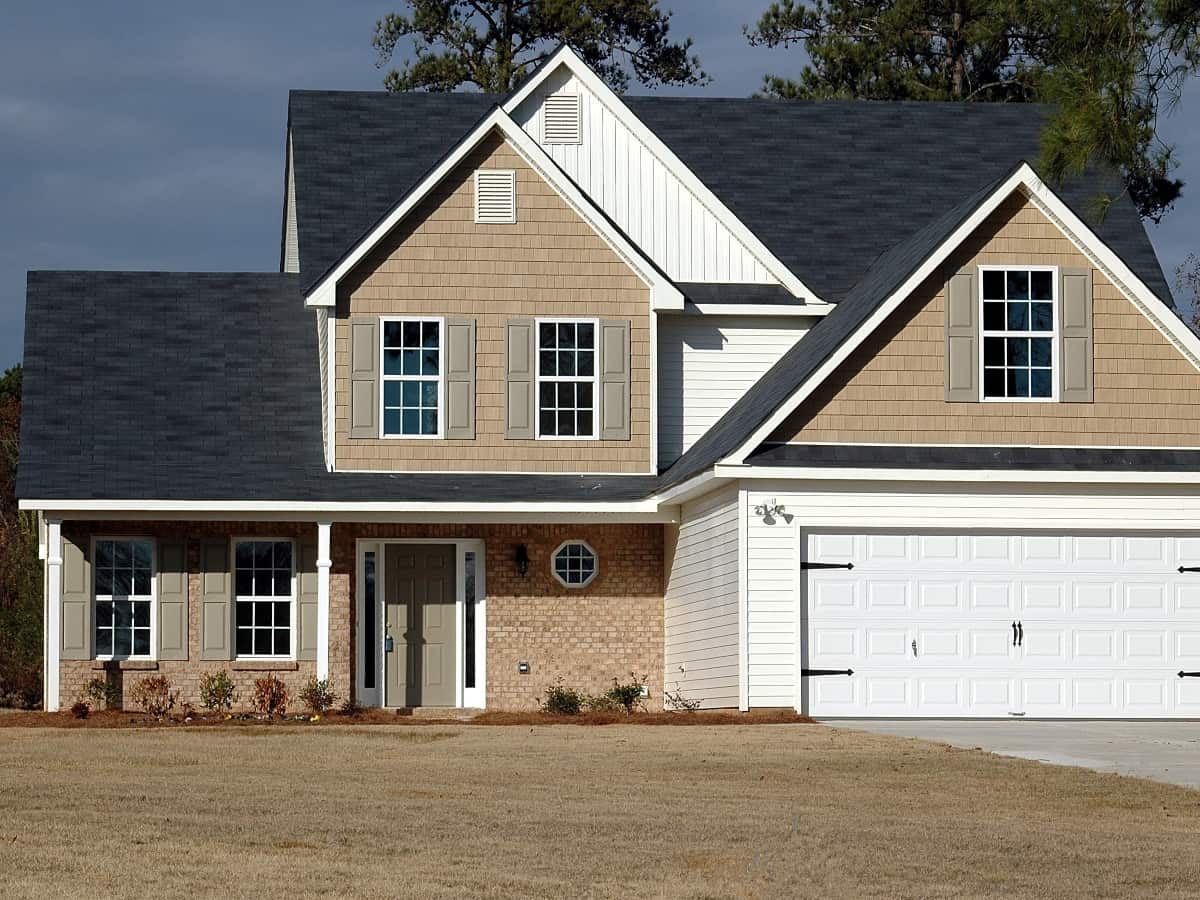 a two story home with windows door and garage door