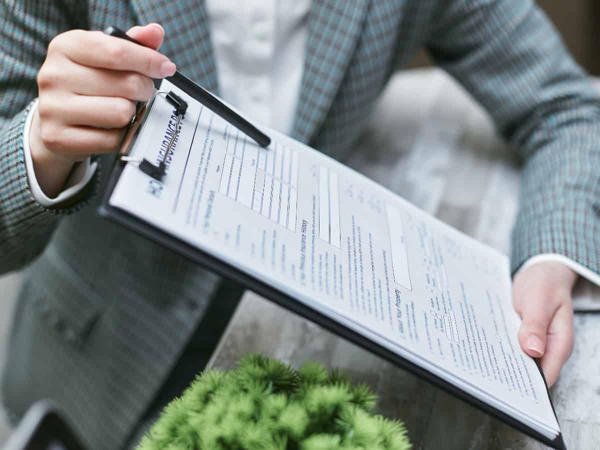 a close up of a pen on a clipboard for home insurance claims and policy