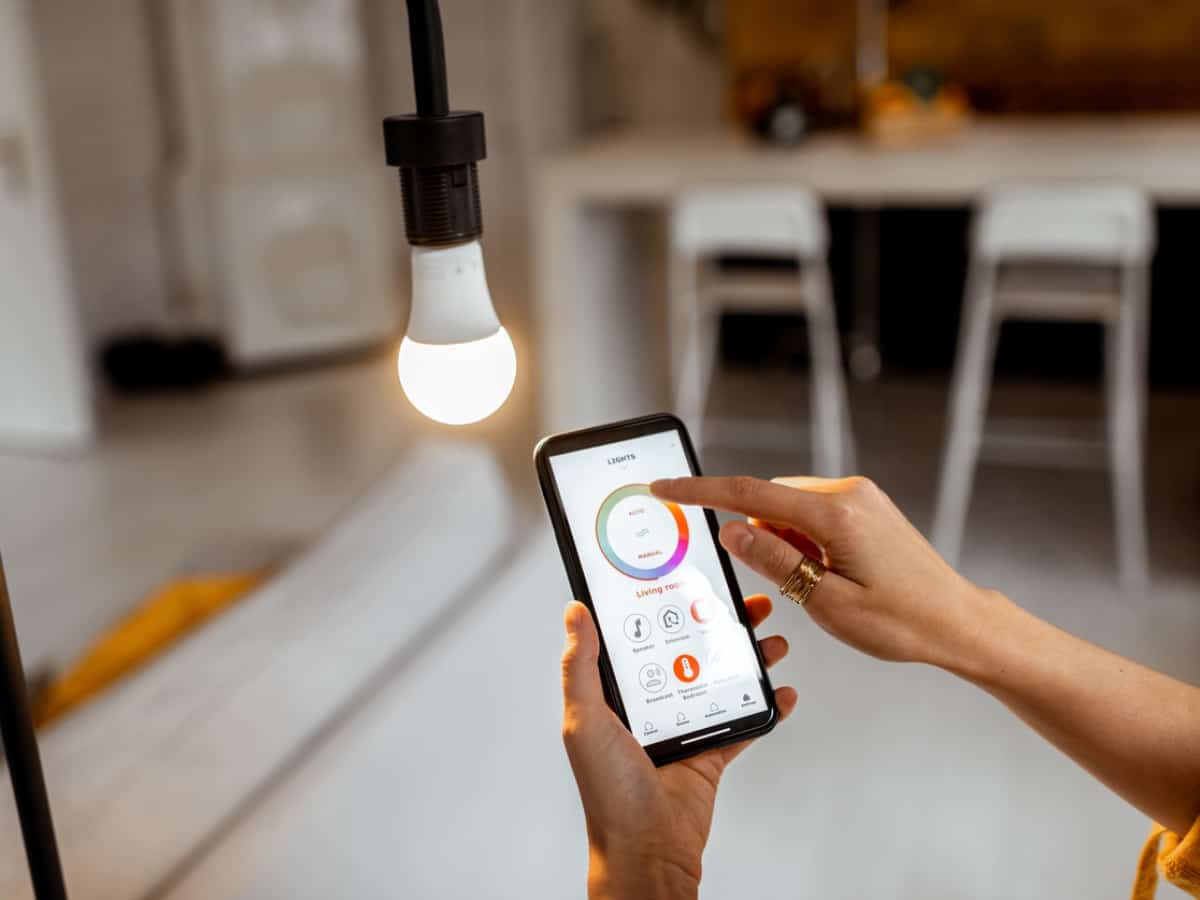 a phone pointed towards smart home light to show how easy it is to control from phone