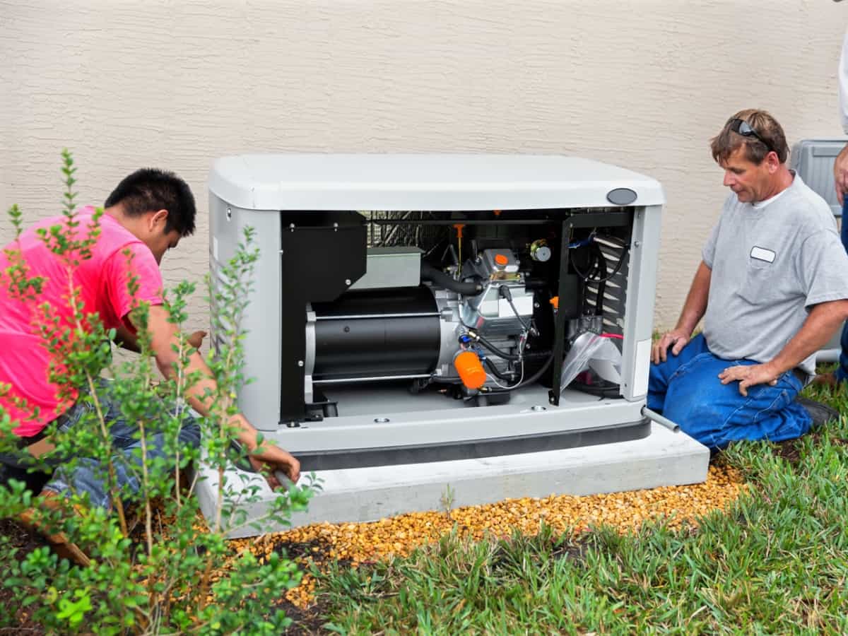 two men setting up a backup home generator for power loss