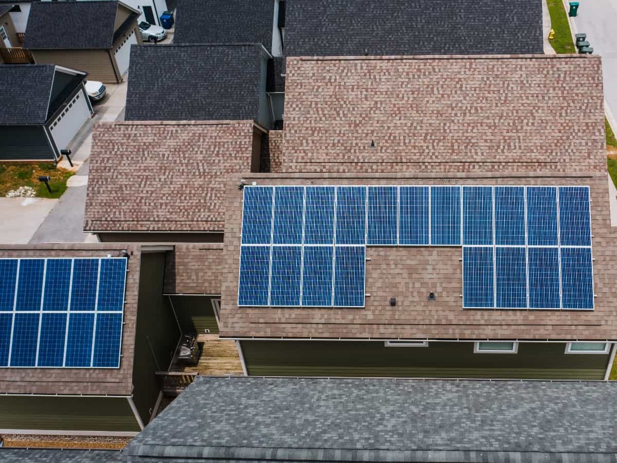 an aerial view of solar panels on a roof in a home and neighborhood