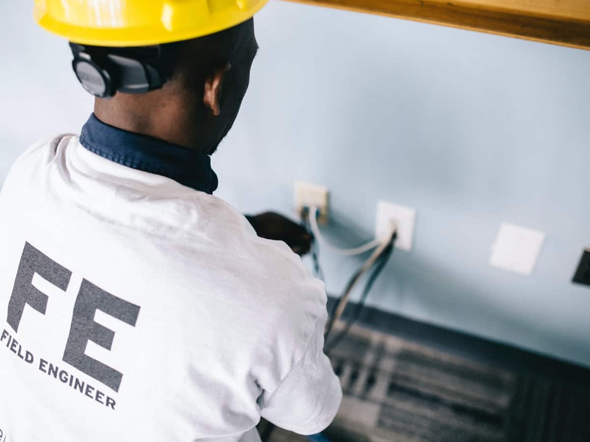 A field engineer is working on wiring inside of a home.