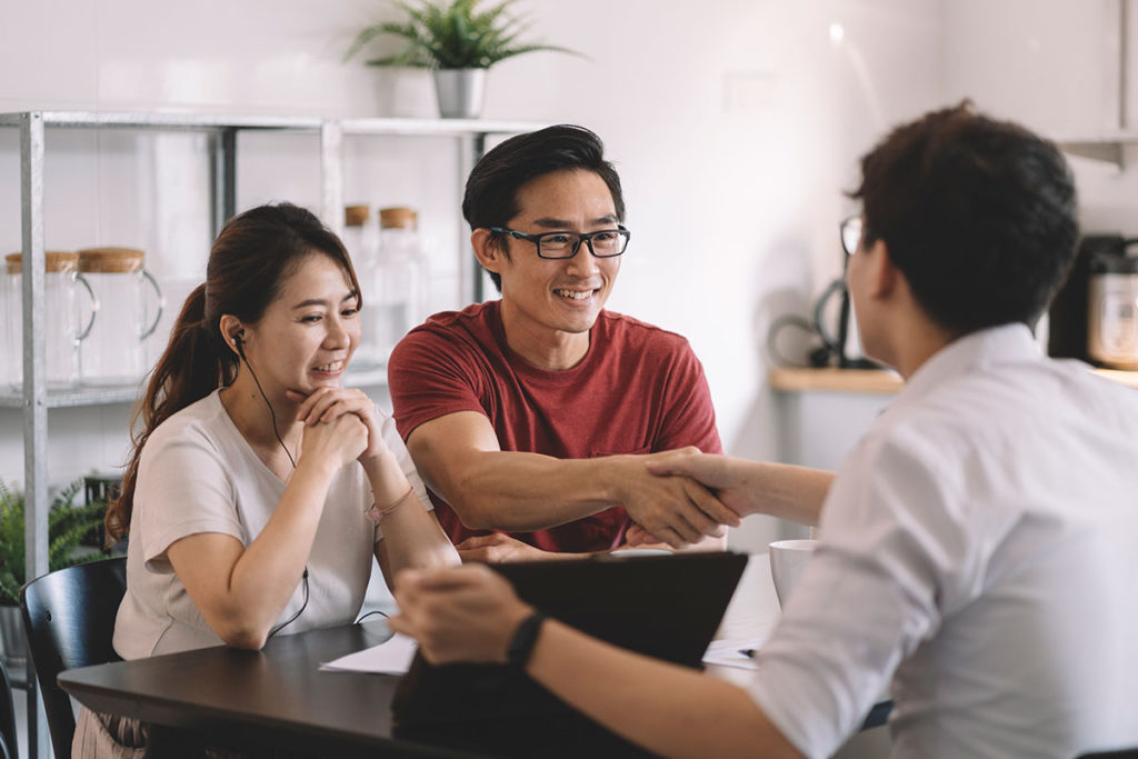 an insurance agent shaking hands with a couple