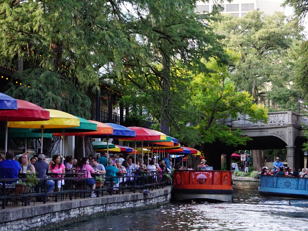 the san antonio riverwalk with a body of water and umbrellas