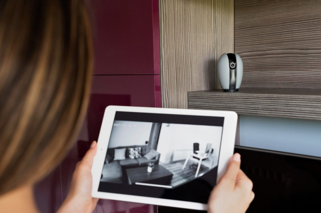 A woman checking security camera footage on an iPad.