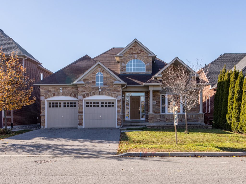 a brown home with two garage doors