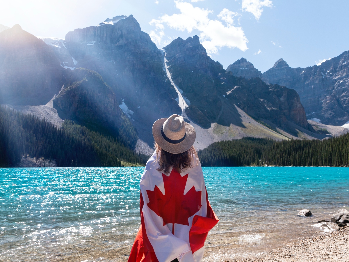 a girl holding the canadian flag in Banff, Canada at Lake Morraine 