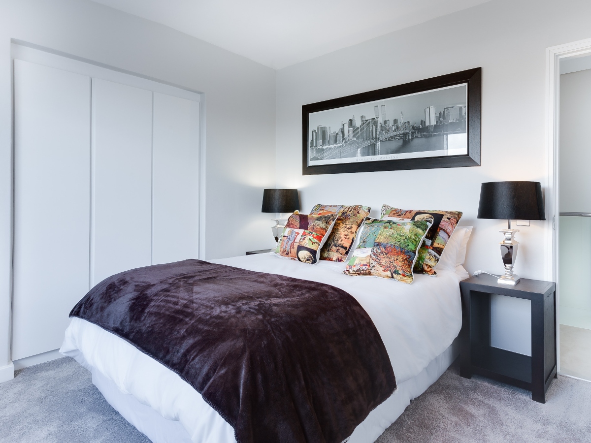 a bedroom with white walls and a lamp in a home