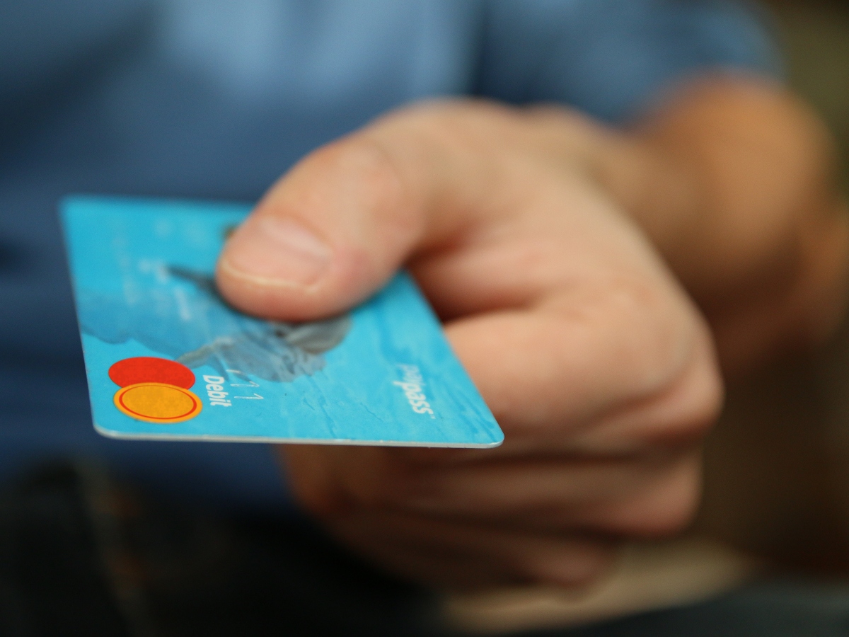 a hand holding a blue mastercard credit card