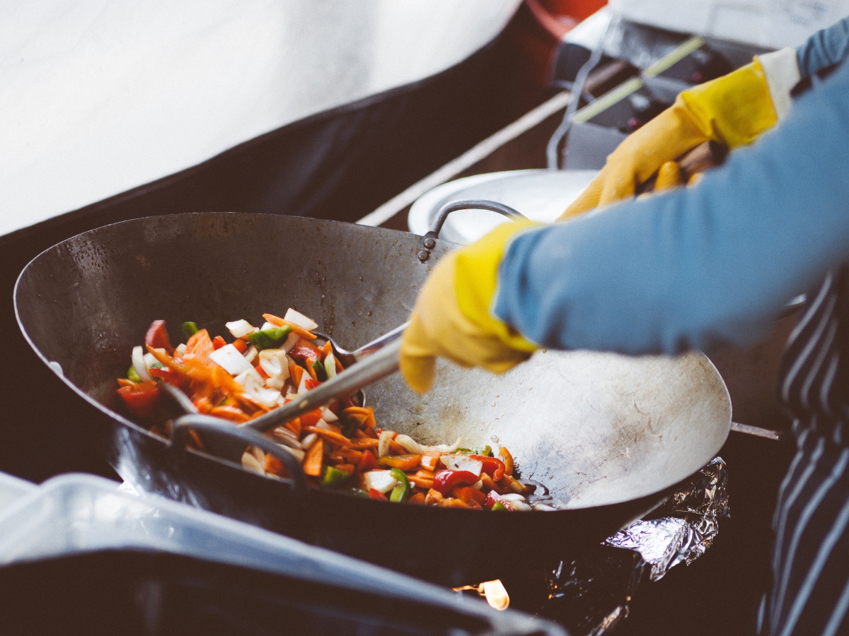 a person making food on a wok cookware that could have teflon making it toxic cookware