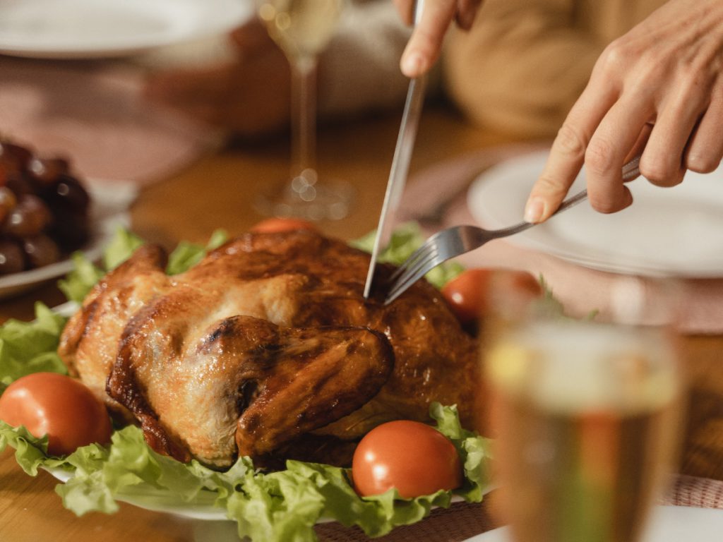 a close up of a thanksgiving turkey with tomatoes and food on the table