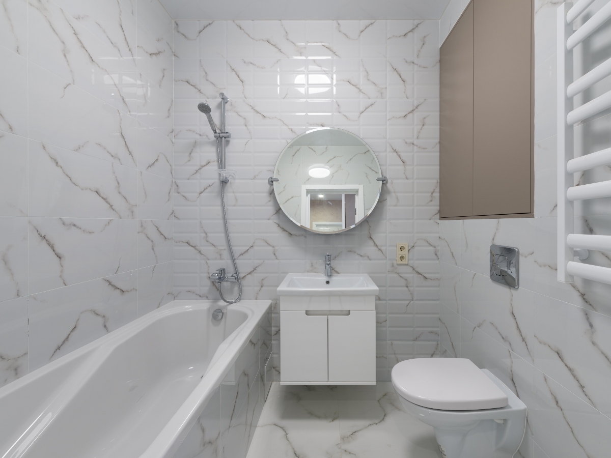 a view of an all white bathroom with vanity sink, toilet and large soaking tub