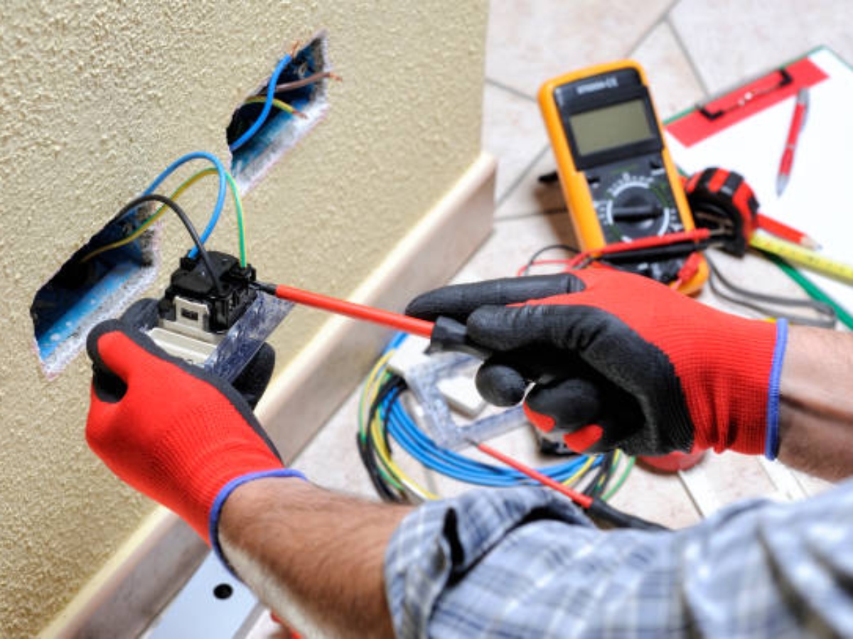 someone working on home wiring with live wires and tools