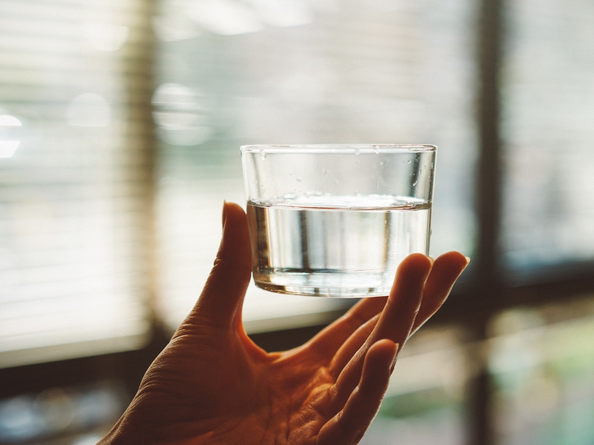 a close up image of a cup of water against a glass window