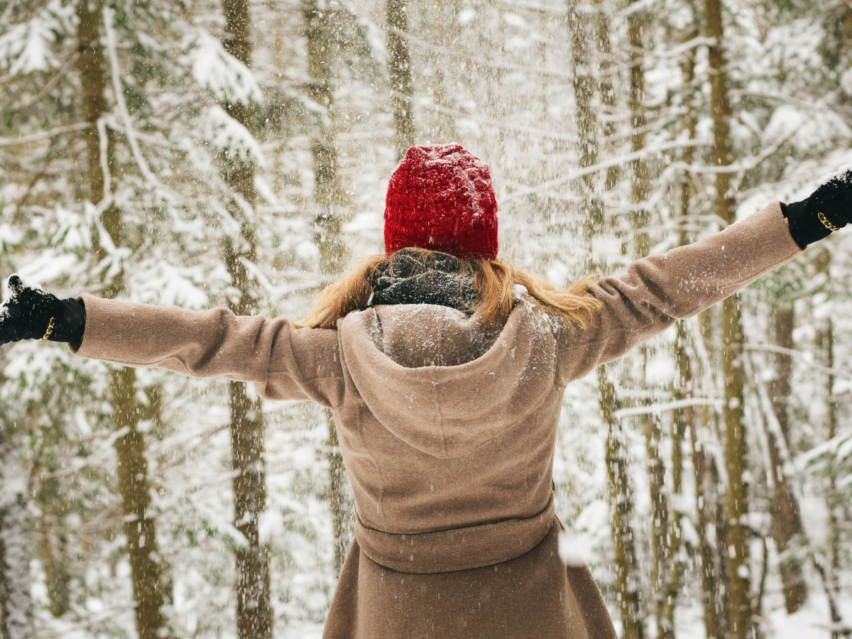 a shot of a woman with her arms out in winter
