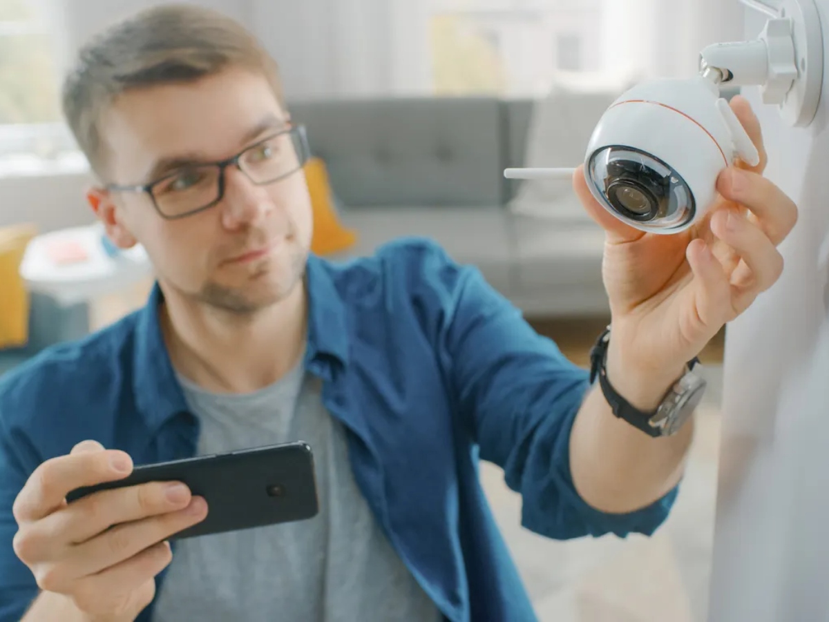 a man installing an indoor home security camera