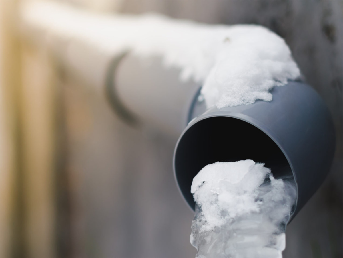 a close up image of a pipe with snow and ice coming out of it
