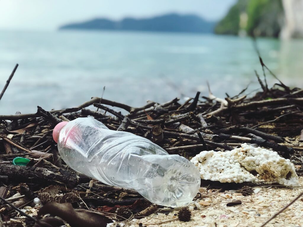 a close up view of a plastic bottle on the beach leading to plastic waste around the country