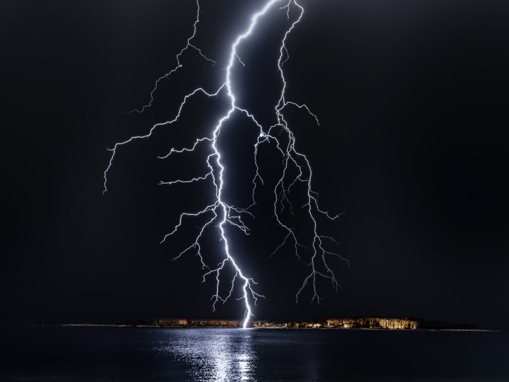 a lightning strike down onto a city during a storm