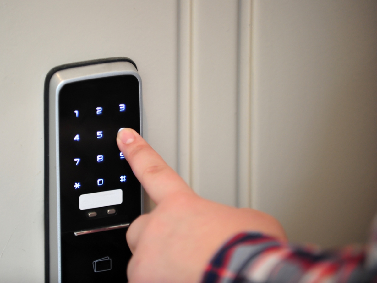 a hand pressing a combination into a smart lock
