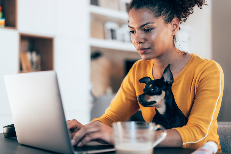 woman working from home with her dog on her lap