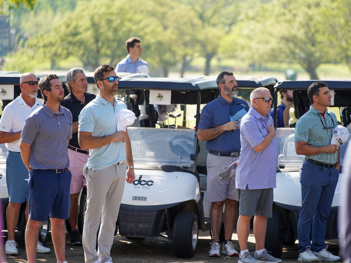 a group of golfers listening to the national anthem at the ONIT Home and The Honor Foundation Annual Golf tournament on April 3, 2023 at the Denton Country Club
