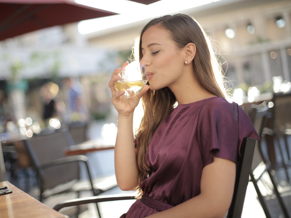 a woman drinking water at a restaurant