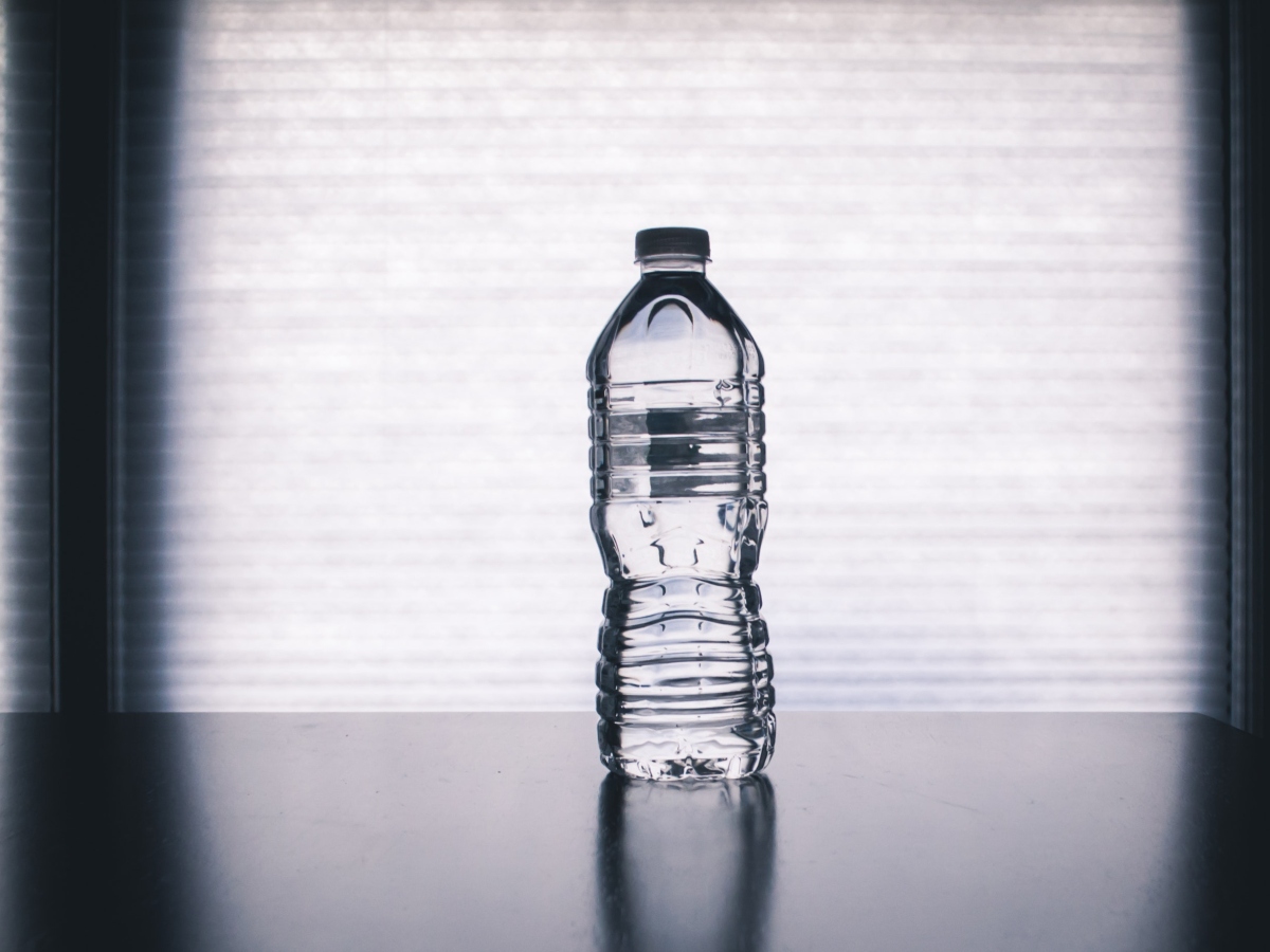 a water bottle against a gray background with dark shadows on both sides