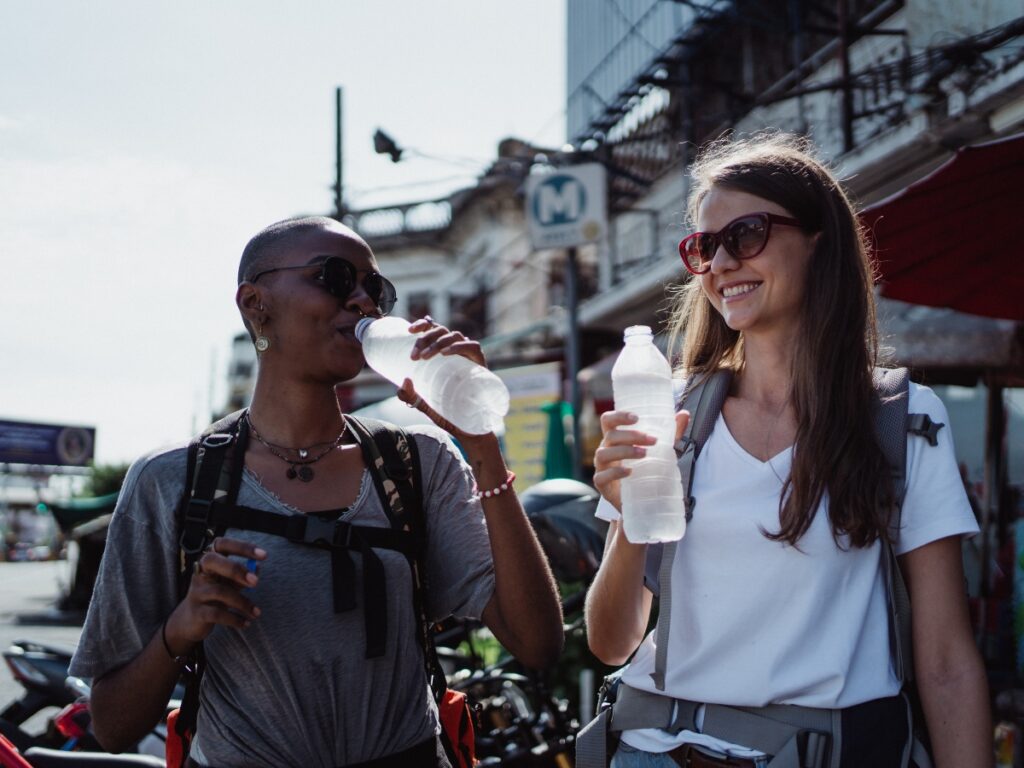 two women walking and holding water bottles on vacation