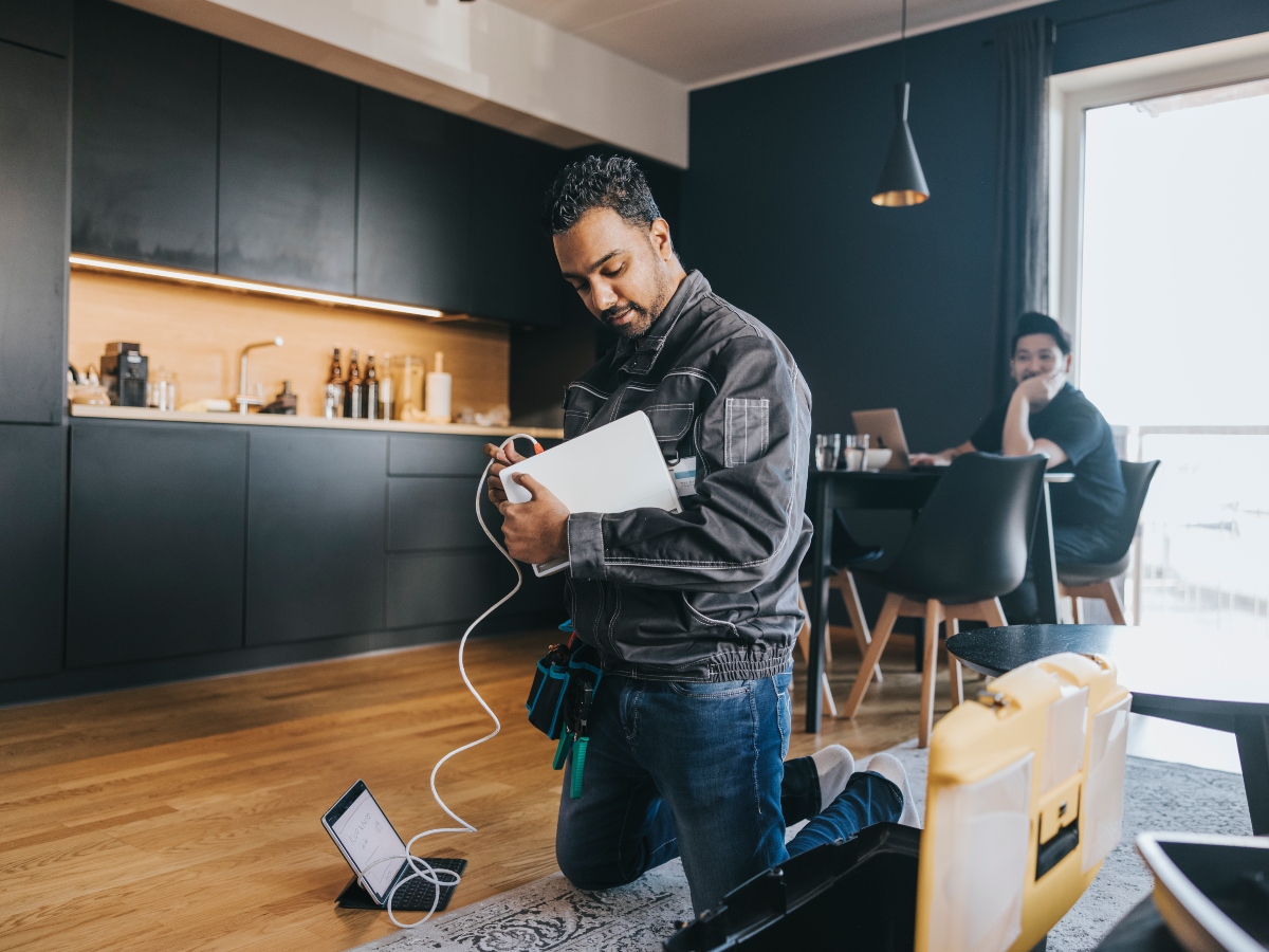 a man kneeling on the ground installing new internet in a new home