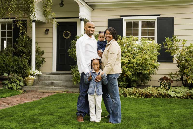family in front of house