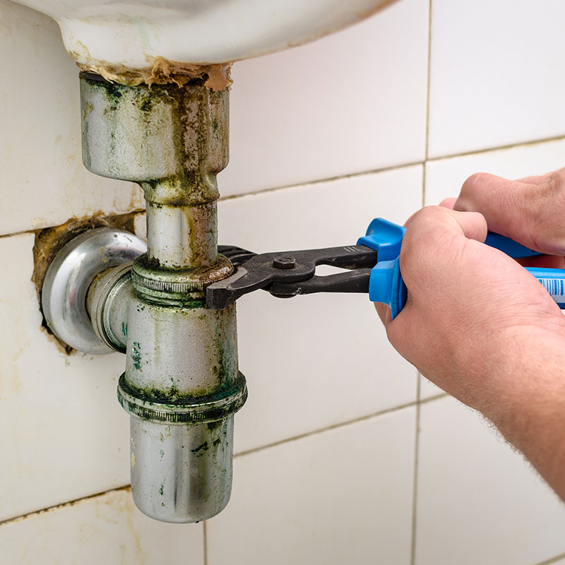 plumber fixing rusted pipes